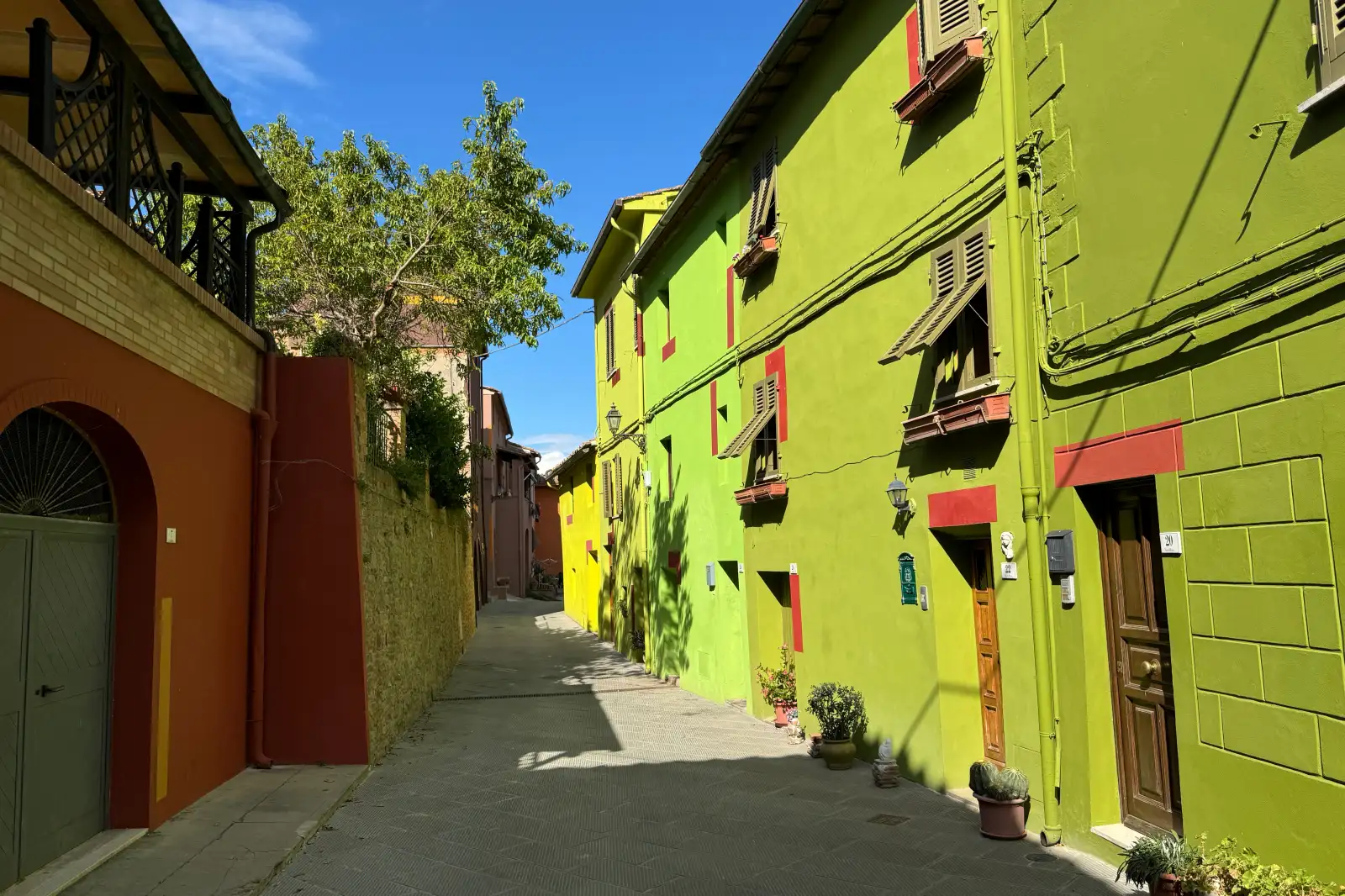 Le facciate verdi, gialle e rosse di Via di Mezzo a Ghizzano, dipinte da David Tremlett