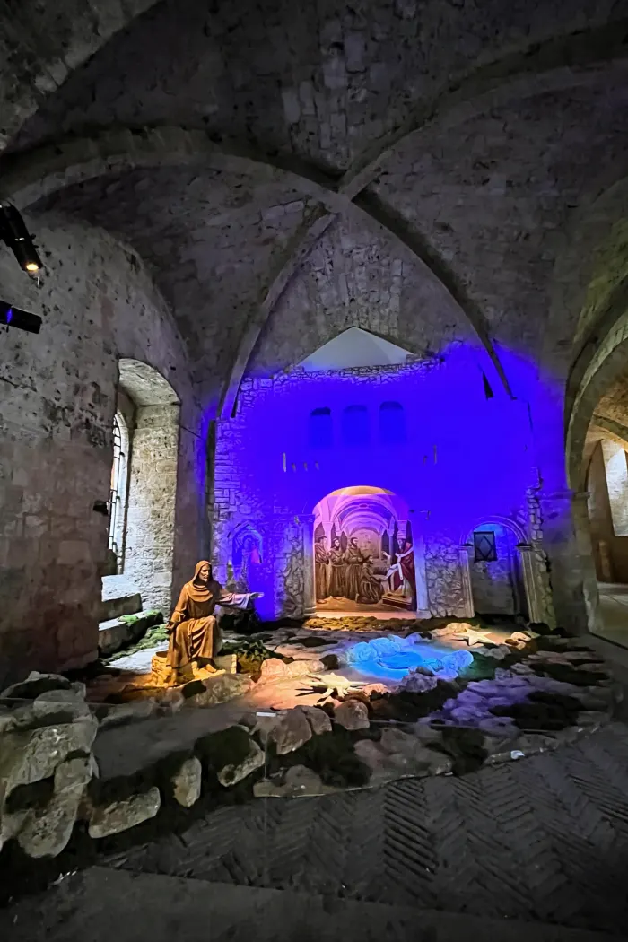 Allestimento della Natività con la statua di San Francesco sotto le volte in pietra a Greccio