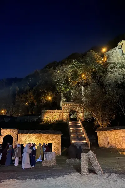Il presepe vivente di Greccio: la scenografia in pietra illuminata di notte con i figuranti in costume