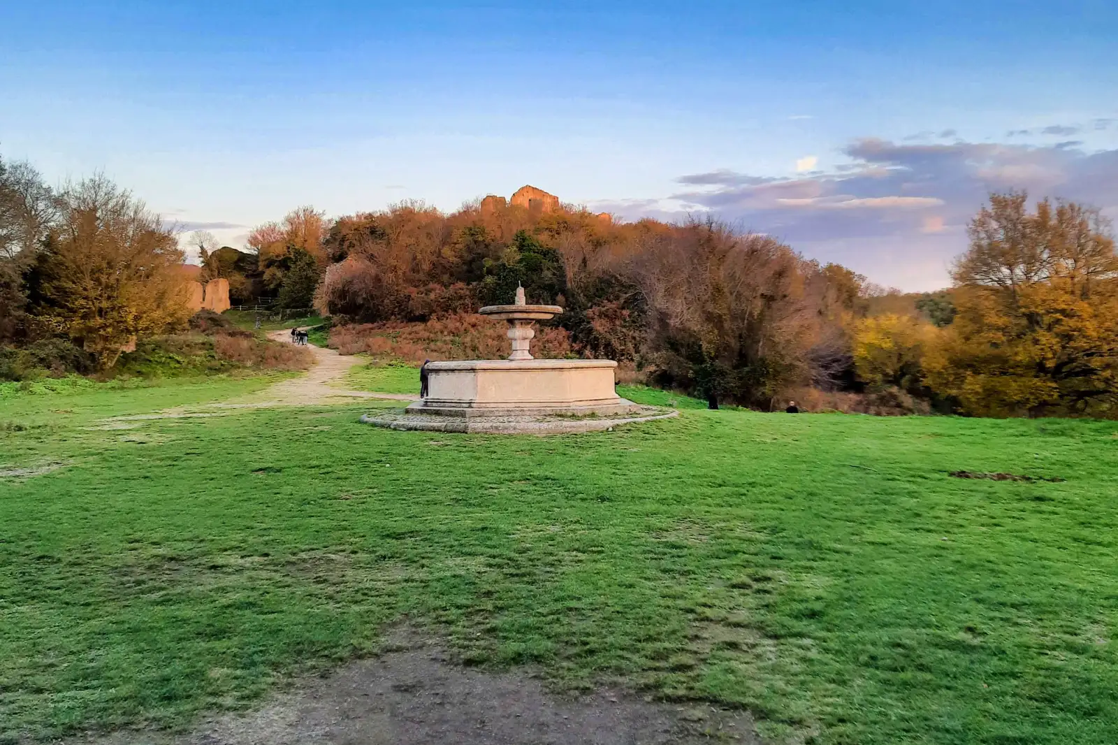Il prato del convento di San Bonaventura al tramonto, con la fontana e lo sperone di tufo di Monterano Antica sullo sfondo