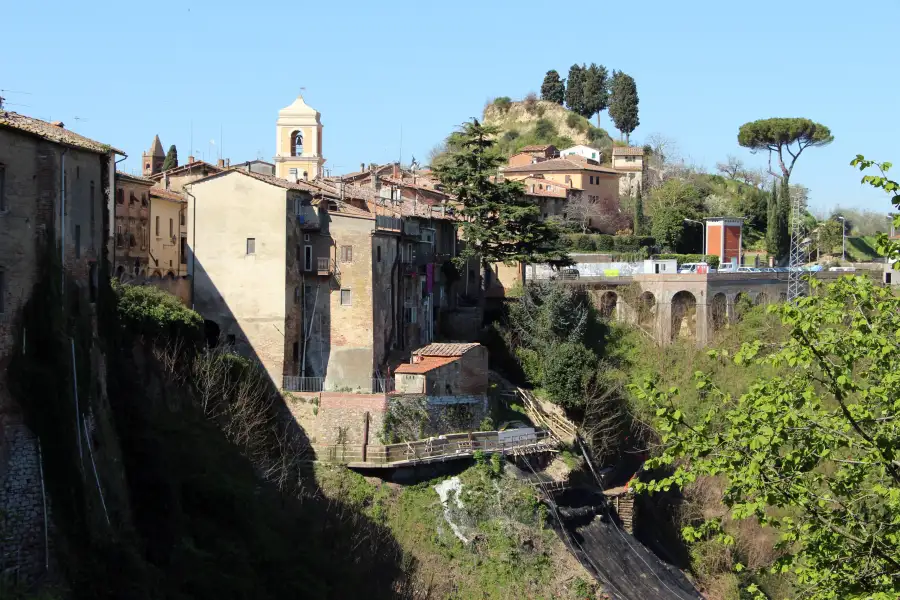 Il borgo di Palaia affacciato sul crinale, con la torre dell’orologio e il viadotto