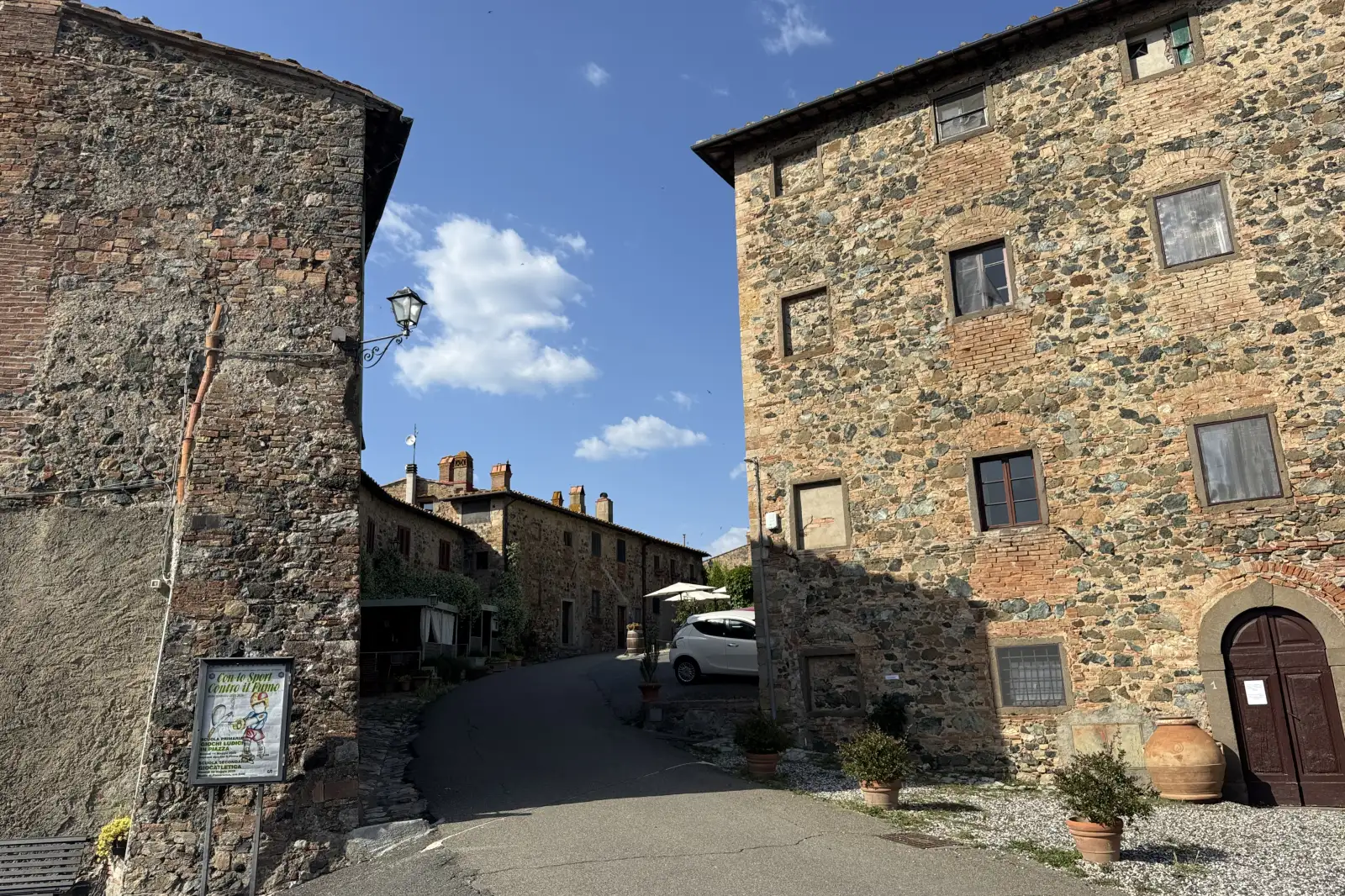Il Castello Ginori coperto di edera visto dalla strada del borgo di Querceto