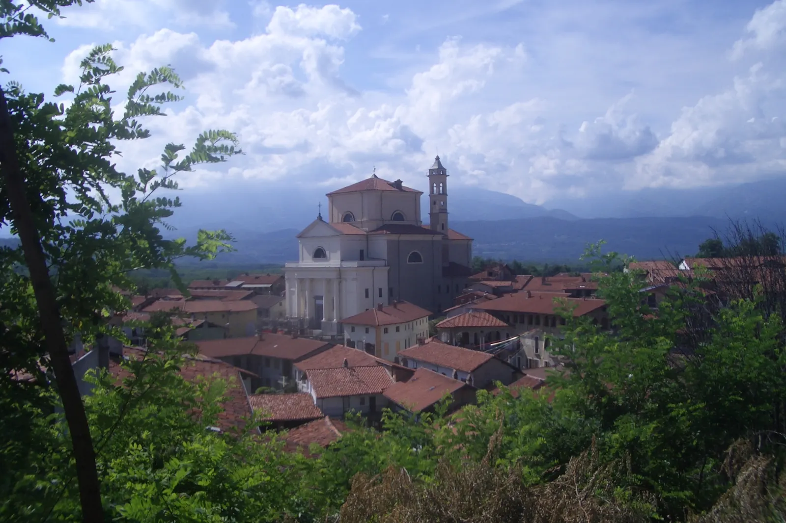 Panorama di Romano Canavese con i tetti del borgo, la chiesa parrocchiale e le montagne sullo sfondo
