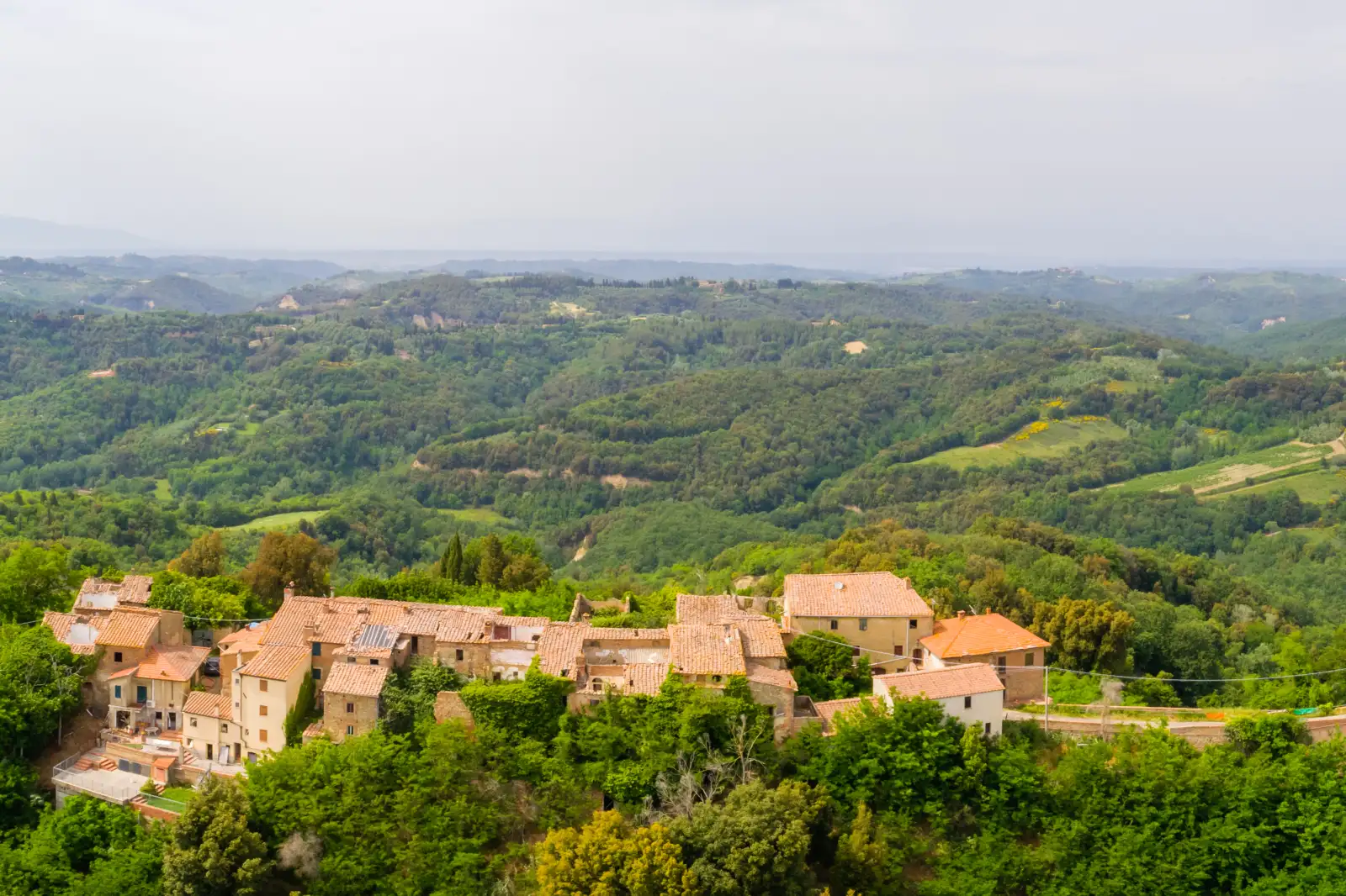Il borgo fantasma di Toiano sul crinale, circondato dalle colline e dai calanchi della Valdera