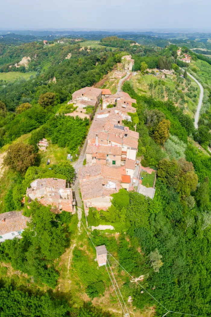 Veduta aerea di Toiano: le case allineate lungo via del Castello sulla stretta lingua di terra