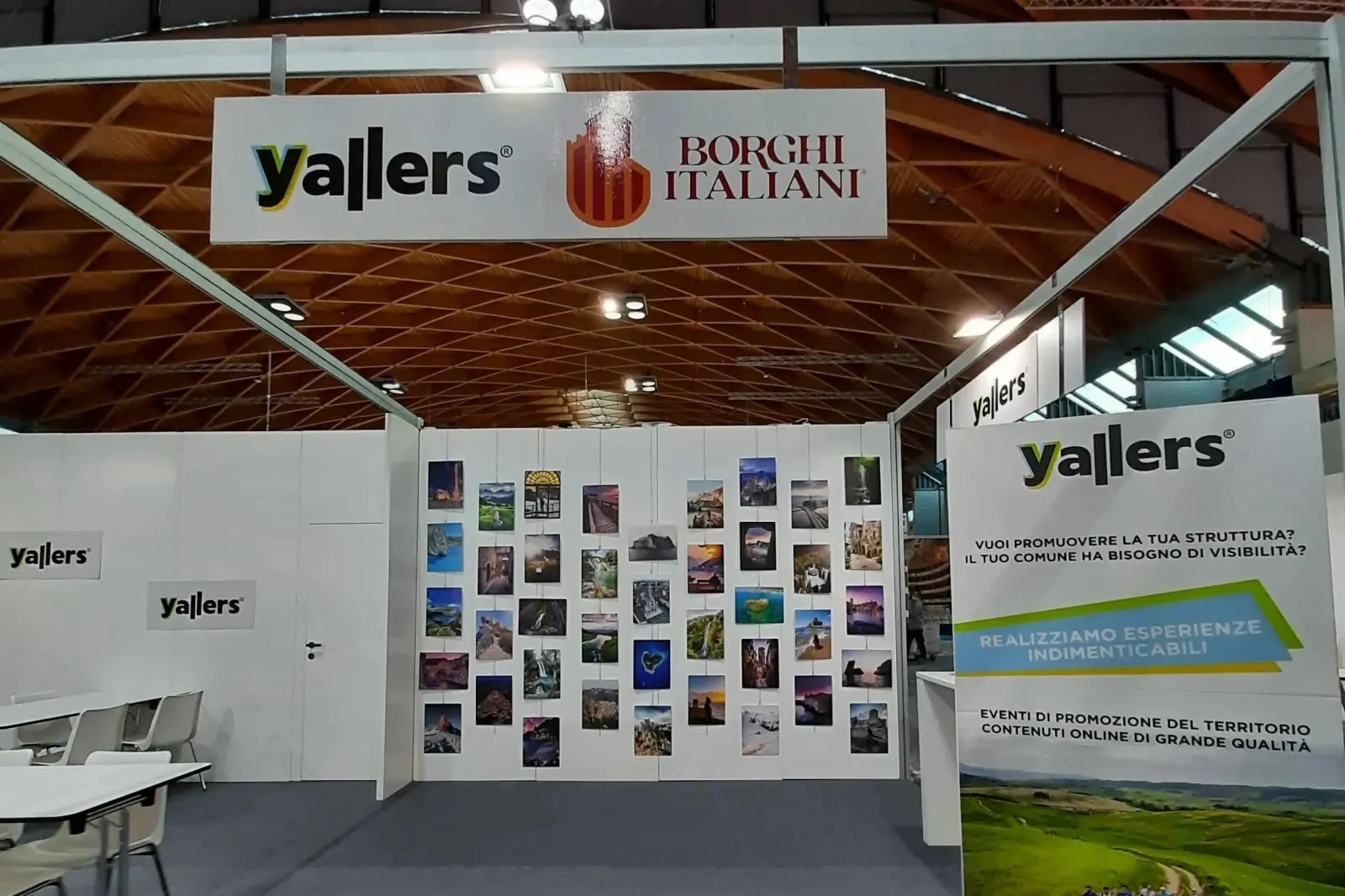 Lo stand Yallers e Borghi Italiani al TTG di Rimini, con l’insegna e la parete di fotografie